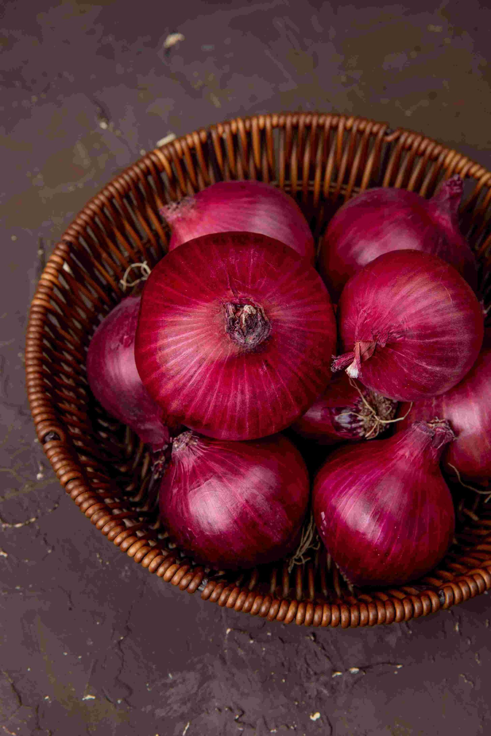 Portfolio top view basket red onions maroon background (1)